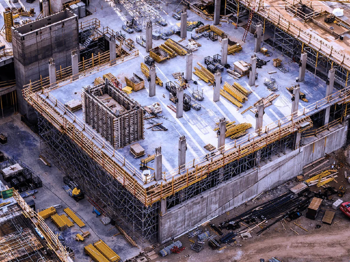 Aerial construction site with cranes and equipment on multi-story building project