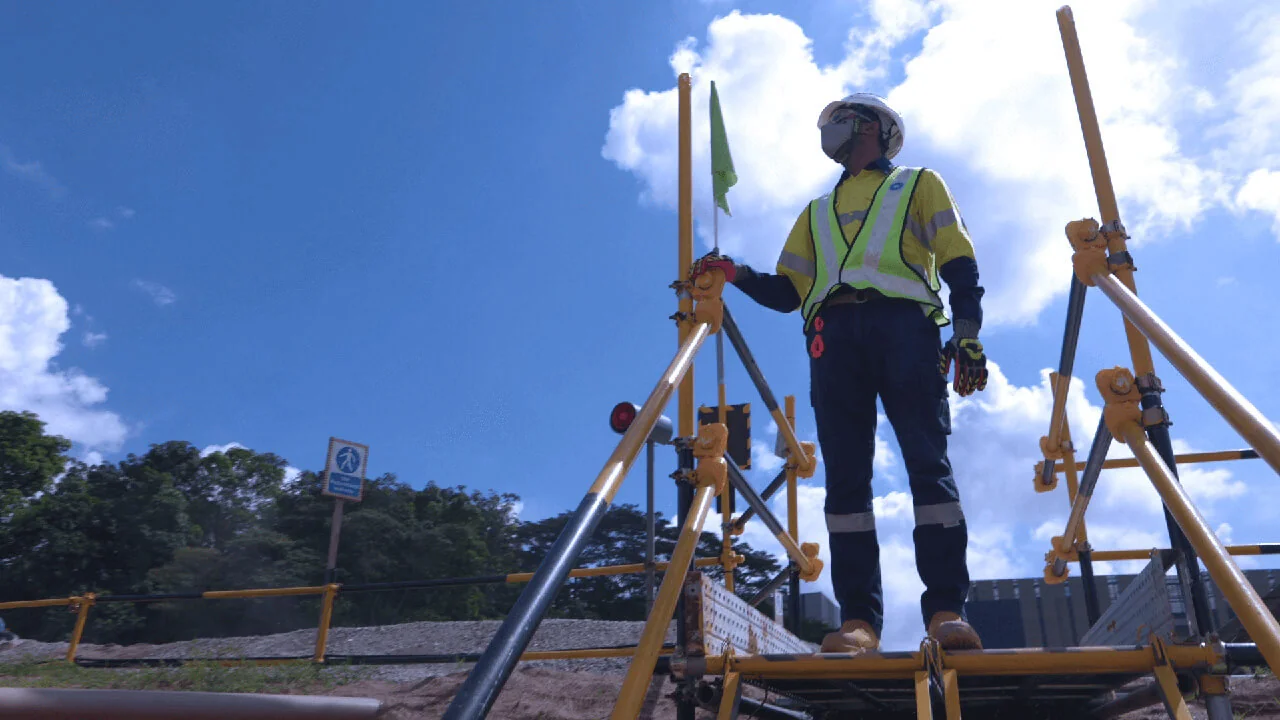 Construction worker in safety gear inspecting scaffolding on site