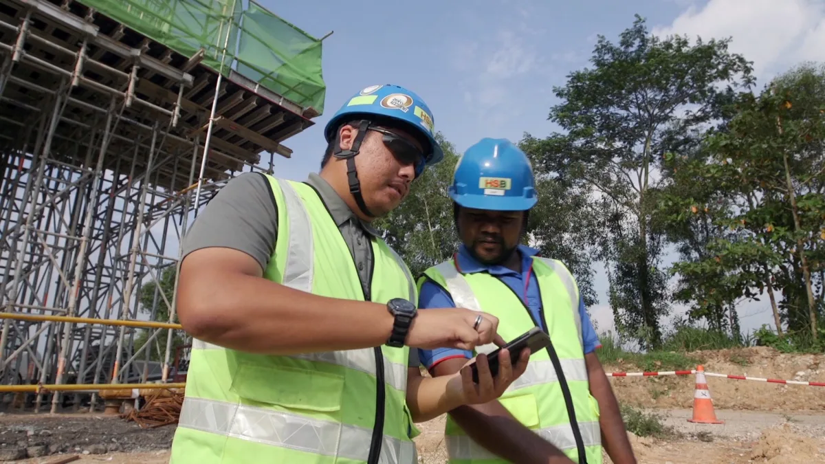 Construction engineers inspecting site data on tablet during active building project