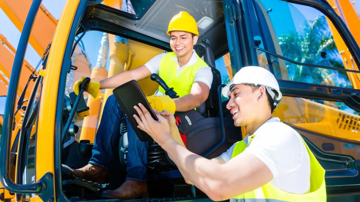 Construction workers using tablet for site safety and compliance management
