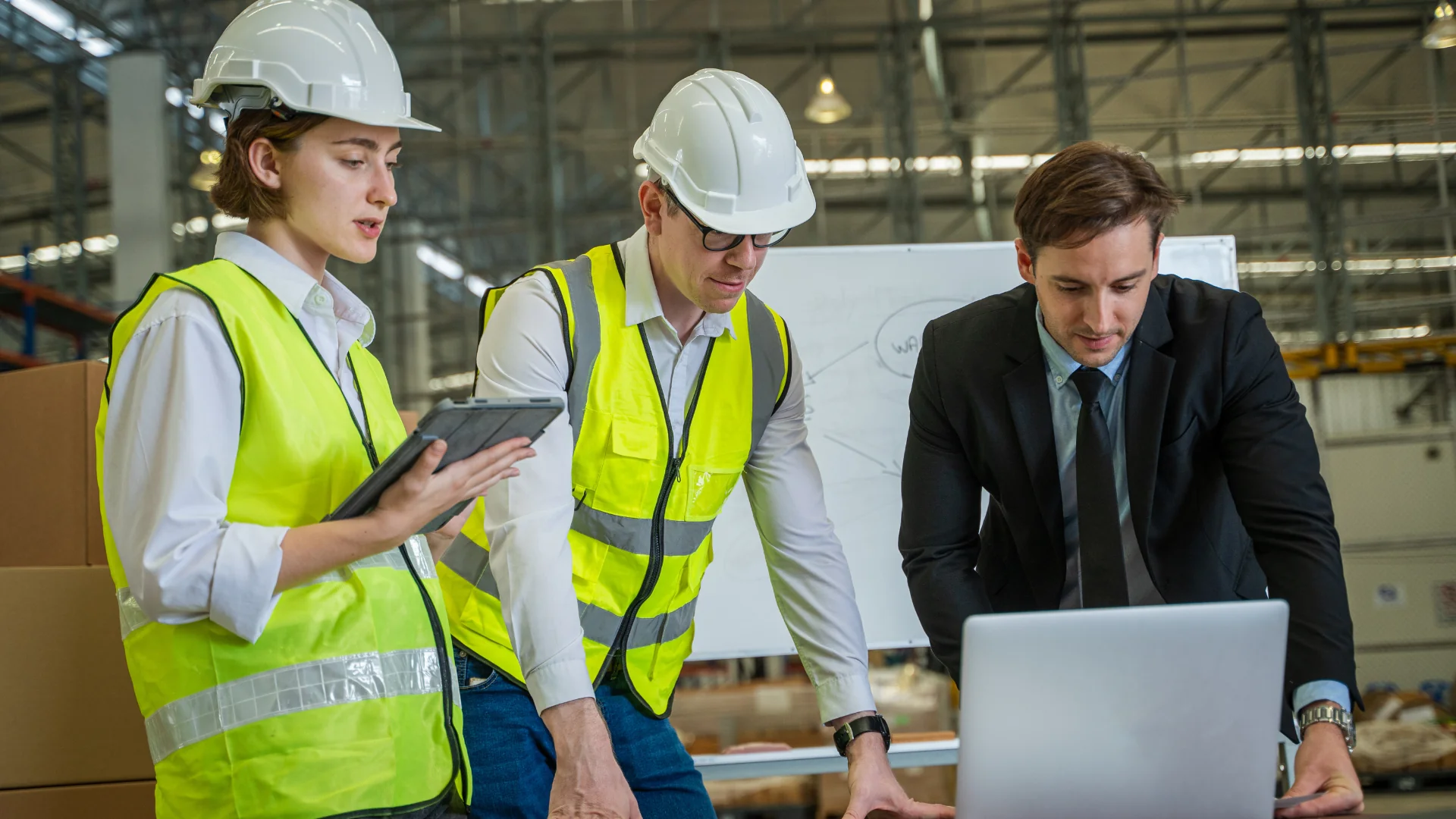 Construction workers and manager reviewing safety management data on tablet