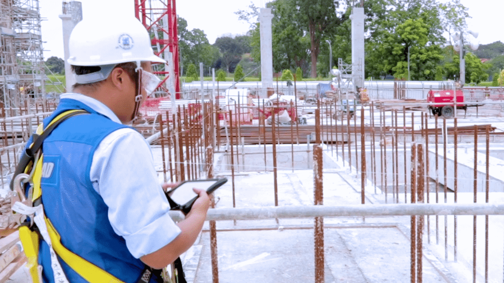Construction supervisor using Novade mobile app on tablet at job site