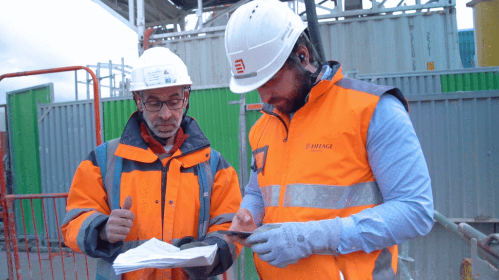 Site engineers reviewing project documentation on active construction site