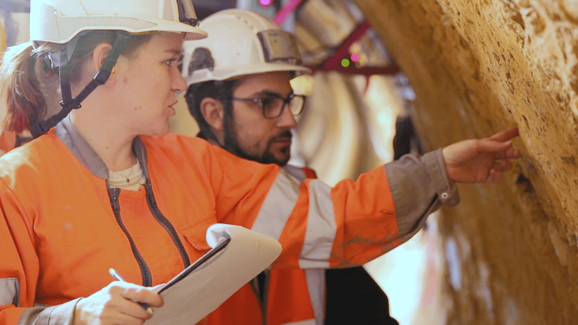 Engineers conducting tunnel quality inspection with safety equipment and documentation