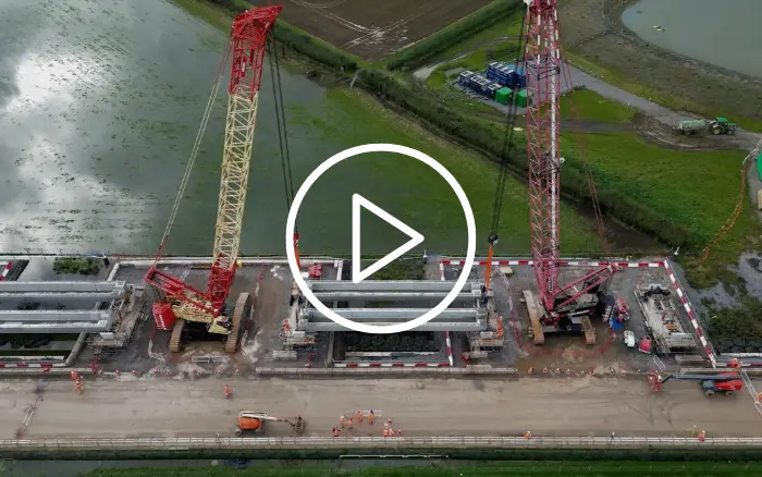 Aerial view of construction site with multiple red cranes and civil works equipment