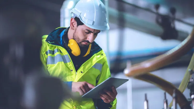 Construction worker using tablet for site inspection and compliance documentation