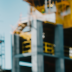 Construction compliance: worker reviewing blueprints on active job site
